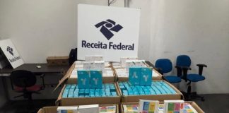 dezenas de caixas de fones de ouvido dentro de caixas de papelão com grande placa da receita federal por cima