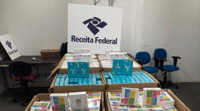 dezenas de caixas de fones de ouvido dentro de caixas de papelão com grande placa da receita federal por cima