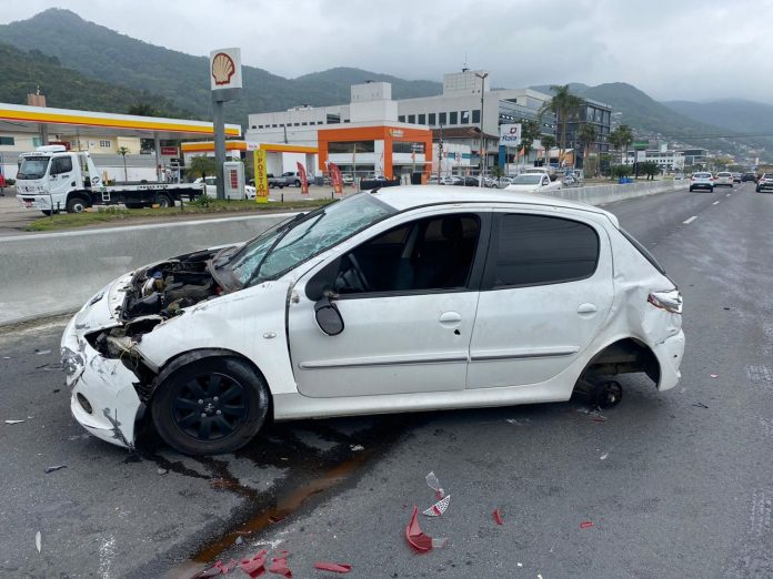 veículo peugeot branco com a frente destruída, sem a roda traseira esquerda