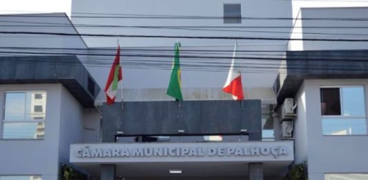 fachada da câmara de vereadores de palhoça com inscrição e bandeiras hasteadas