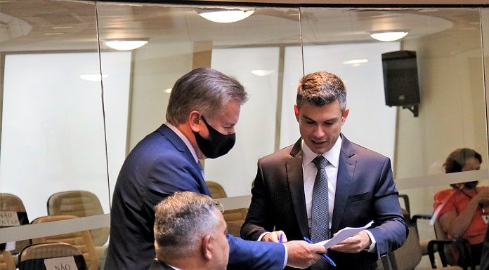 Inicia a tramitação da Pec de eleição direta em SC bruno souza, sem máscara, fala com outro deputado de máscara no plenário da alesc; outro deputado sentado olha para trás para eles