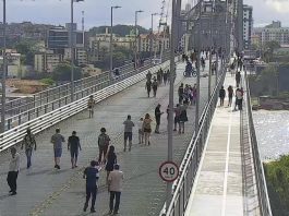 Pesquisa do TCE revela que 83% dos municípios não têm políticas públicas de igualdade racial pessoas andando na ponte hercílio luz pelas passarelas e vão central