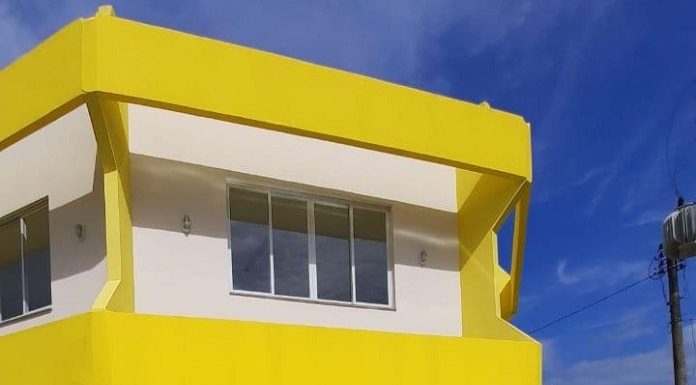 fachada amarela e branco do prédio de dois andares