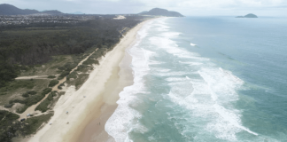 Imagem aérea de praia do litoral catarinense - alerta de ventos e agitação matítima