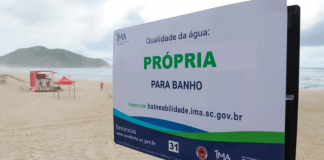 Placa na praia informando que a água está própria para banho