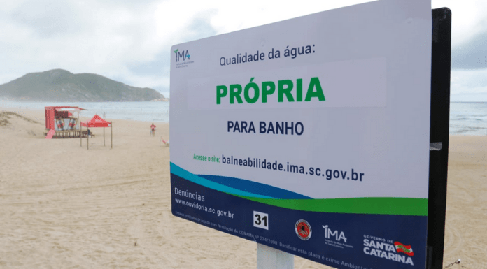 Placa na praia informando que a água está própria para banho