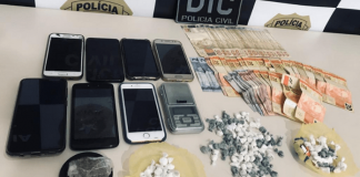 sobre uma mesa apreensões do delivery de cocaína: oito celulares, dinheiro e cocaína