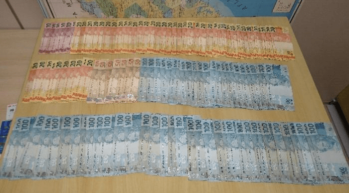 Cédulas de 100, 50, 20 e 10 reais na mesa da PMSC