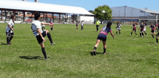 Meninas jogando futebol de campo ao ar livre