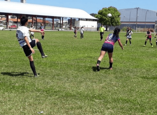 Liberadas as competições esportivas em regiões graves na matriz de risco de SC Meninas jogando futebol de campo ao ar livre