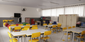 Sala de aula, com mesas e cadeiras vazias