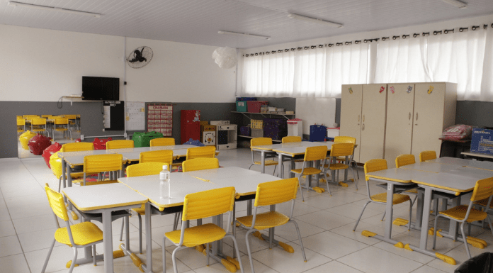 Sala de aula, com mesas e cadeiras vazias