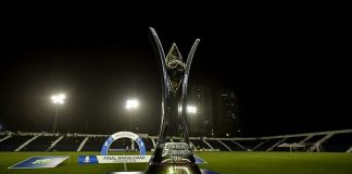 taça do campeonato brasileiro feminino sobre palanque em campo de futebol à noite