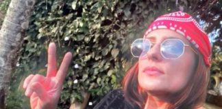 raphaela sarah faz sinal de V em selfie; ela usa bandana na cabeça e óculos escuros