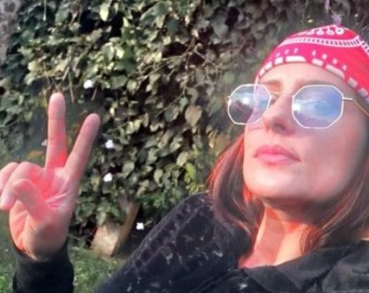 raphaela sarah faz sinal de V em selfie; ela usa bandana na cabeça e óculos escuros