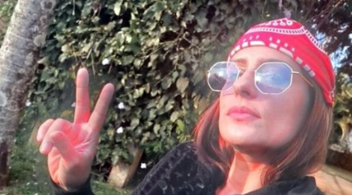 raphaela sarah faz sinal de V em selfie; ela usa bandana na cabeça e óculos escuros