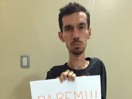 Vereador eleito em Joinville também é ameaçado de morte por repudiar ataque à vereadora alisson mostra um papel para foto escrito "parem!!!"; ele olha sério para a câmera