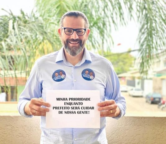 lemos posa sorridente para a foto com uma placa dizendo: Minha prioridade enquanto prefeito será cuidar de nossa gente!