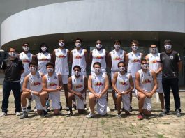 equipe masculina do basket são josé posa para a foto de uniforme. Seis estão com o joelho apoiado no chão e oito em pé, ao lado de dois membros da comissão técnica vestidos de preto.