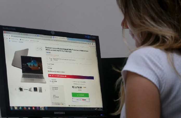 mulher olha para tela de computador com compras - fraudes e golpes bancários virtuais - como evitá-los