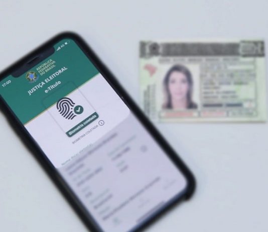 Aplicativo da justiça eleitoral facilita justificativa de ausência nas eleições deste ano aplicativp e-título em tela de celular com título eleitoral ao lado