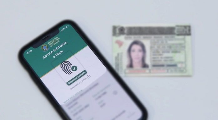 aplicativp e-título em tela de celular com título eleitoral ao lado