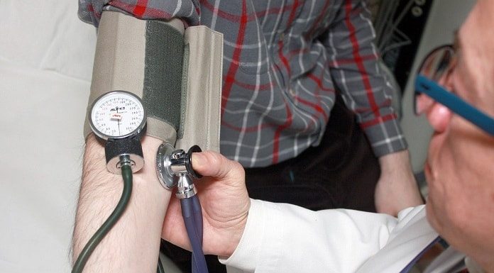 médico faz medição de pressão no braço de paciente