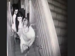 MP reafirma que réu foi absolvido por falta de provas por estupro de vulnerável Réu foi absolvido: imagem de câmera de segurança mostra andré e mariana subindo pequena escada estreita; homem ao fundo abrindo a porta