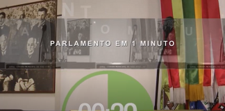 abertura do programa parlamento em um minuto, da tv câmara sao josé, com o nome escrito, um timer contato 29 segundo, uma bandeira de santa catarina no canto direito, uma mesa sinalizada como câmara de são josé e quadros ao fundo