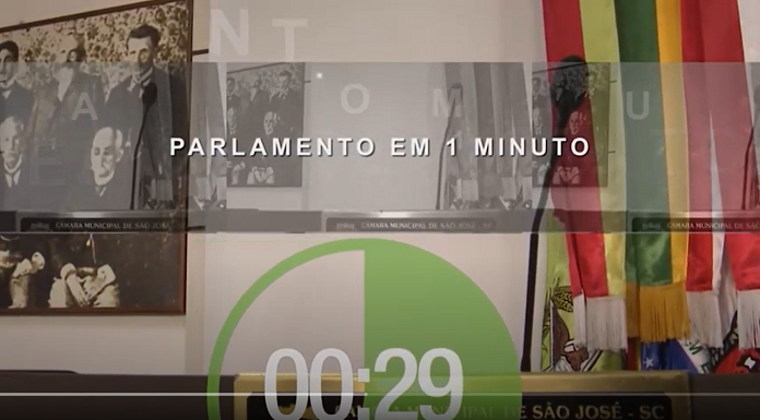 abertura do programa parlamento em um minuto, da tv câmara sao josé, com o nome escrito, um timer contato 29 segundo, uma bandeira de santa catarina no canto direito, uma mesa sinalizada como câmara de são josé e quadros ao fundo