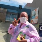 salum usa máscara e faz o V com os dedos para a foto