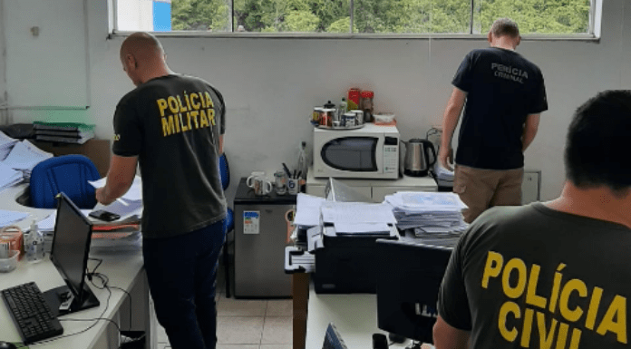 Um policial civil, um militar e um da perícia criminal vendo documentos