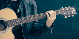 Homem com jaqueta de couro tocando violão