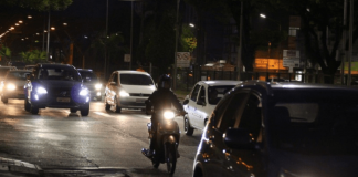 Carros e uma moto de noite nas ruas de Criciúma