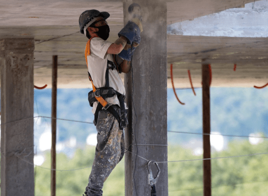 Homem com equipamentos de EPI, realizando obra