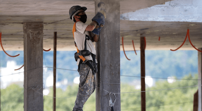 Homem com equipamentos de EPI, realizando obra