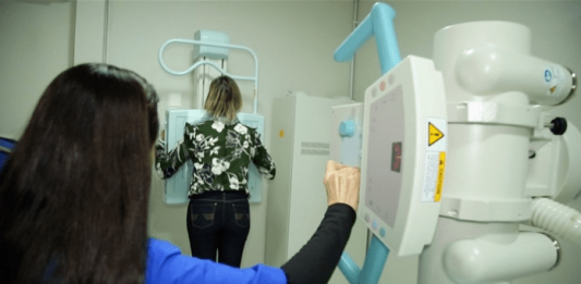 Postos de saúde abrem neste sábado para mutirão do Outubro Rosa Profissional da saúde realizando exame de mama em paciente