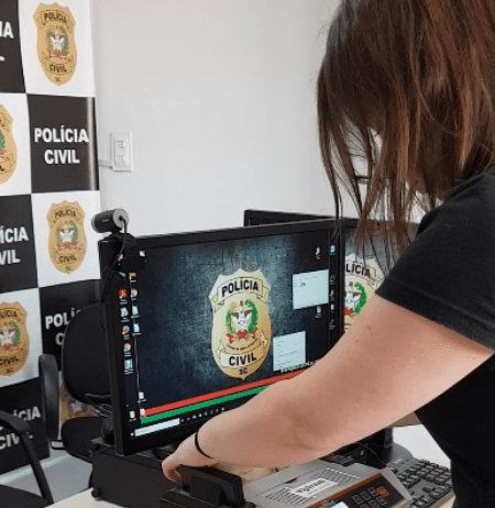 Operação Soldo Inflado investiga esquema ilegal de horas extras em Blumenau Agente da Polícia Civil contando dinheiro