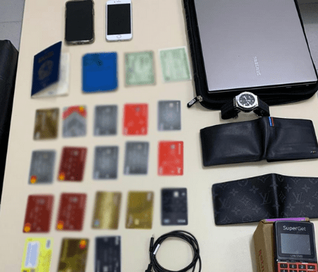 Cartões de crédito clonados, carteiras, celulares e uma placa da Polícia Civil de Santa Catarina em cima da mesa