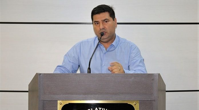 Vereador Nardi Arruda, de camisa social azul apresentando o novo projeto