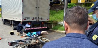 para conscientizar motociclistas: homem olha moto e boneco caídos atrás de caminhão, com prf ao lado