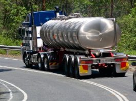 Restrições tráfego caminhões - Caminhão; veículo longo andando na rodovia com um carro atrás na pista