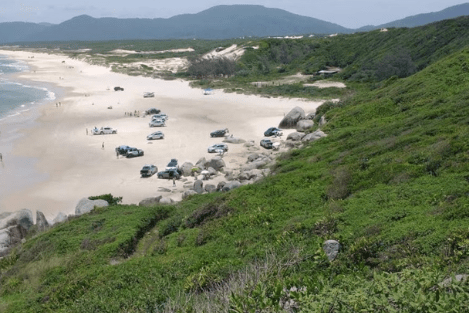 Praia do Moçambique vista de cima do morro; na faixa de areia tem carros