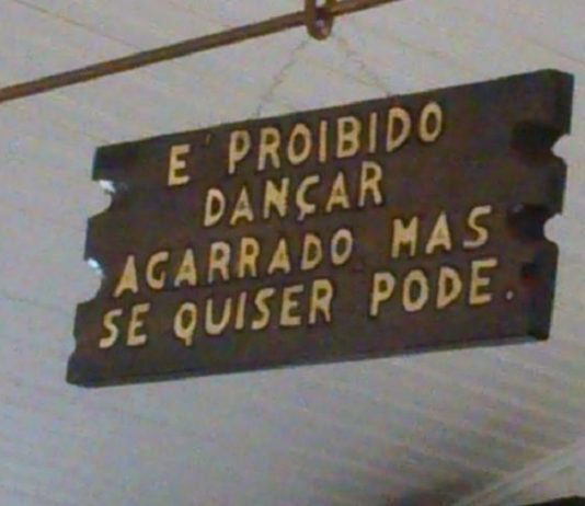 placa dizendo "é proibido dançar agarrado mas se quiser pode"