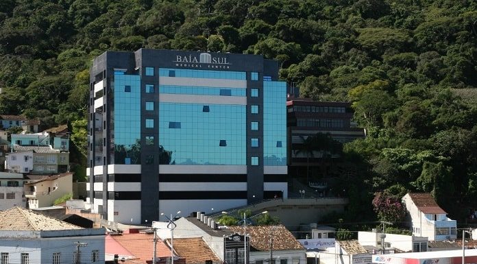 Hospital Baía Sul, em Florianópolis, visto entre outros imóveis e morro com mata atrás