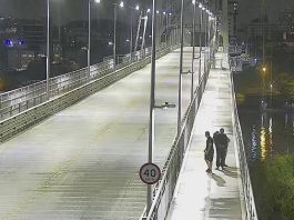 Decreto do toque de recolher é publicado, com vigor entre 5 e 19 de dezembro decreto do toque de recolher em sc: ponte hercílio luz à noite, com três pessoas andando na passarela