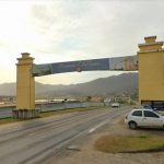 tpa de governador celso ramos - portal de entrada da cidade com montanha ao fundo; carro ao lado; estrada sob portal