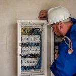 vagas de emprego no sine de santa catarina - homem usando capacete olha para painel de fusíveis
