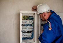 vagas de emprego no sine de santa catarina - homem usando capacete olha para painel de fusíveis