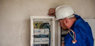 vagas de emprego no sine de santa catarina - homem usando capacete olha para painel de fusíveis